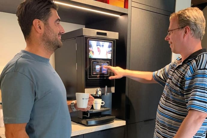Collega’s maken samen koffie op kantoor